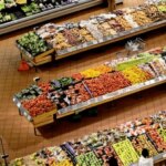 Вид зверху на торговий зал супермаркету з рядами свіжих овочів та фруктів