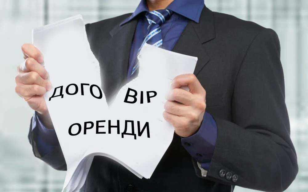 Чоловік у костюмі розриває папір із написом договір оренди