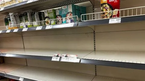 Порожні полиці супермаркету з пачками круп і цінами на верхній полиці