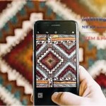 Рука тримає смартфон і фотографує геометричний орнамент традиційного килима